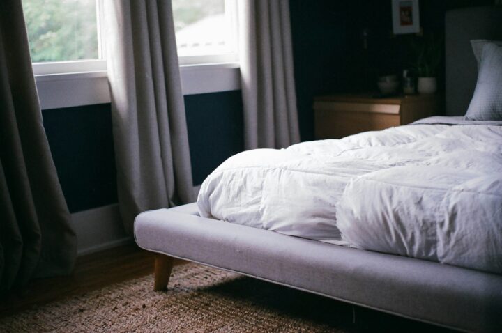 white bed by the white bed by the window during daytime